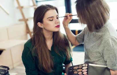 Makeup artist appling makeup to woman